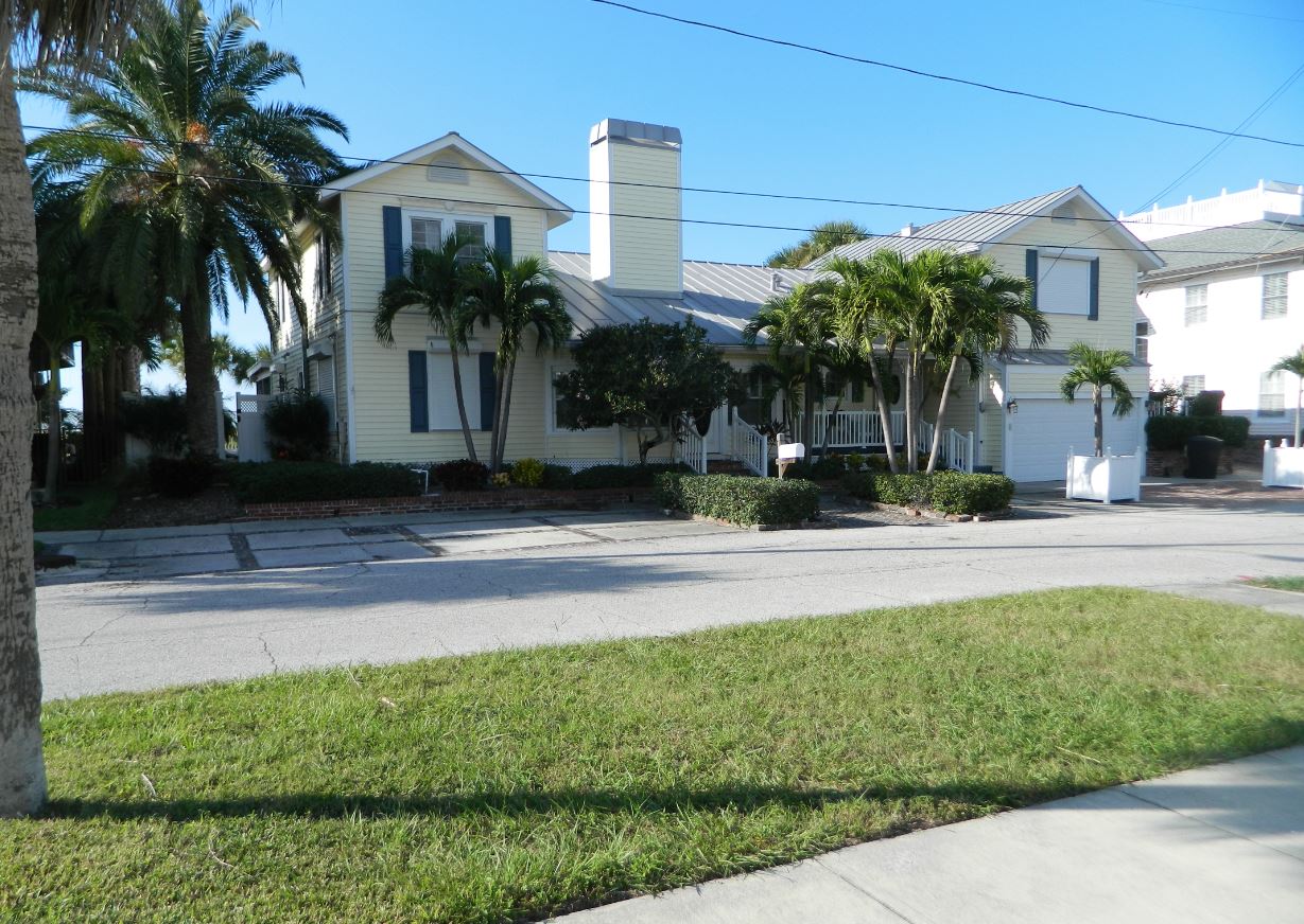 Two-story house with palm trees and lawn