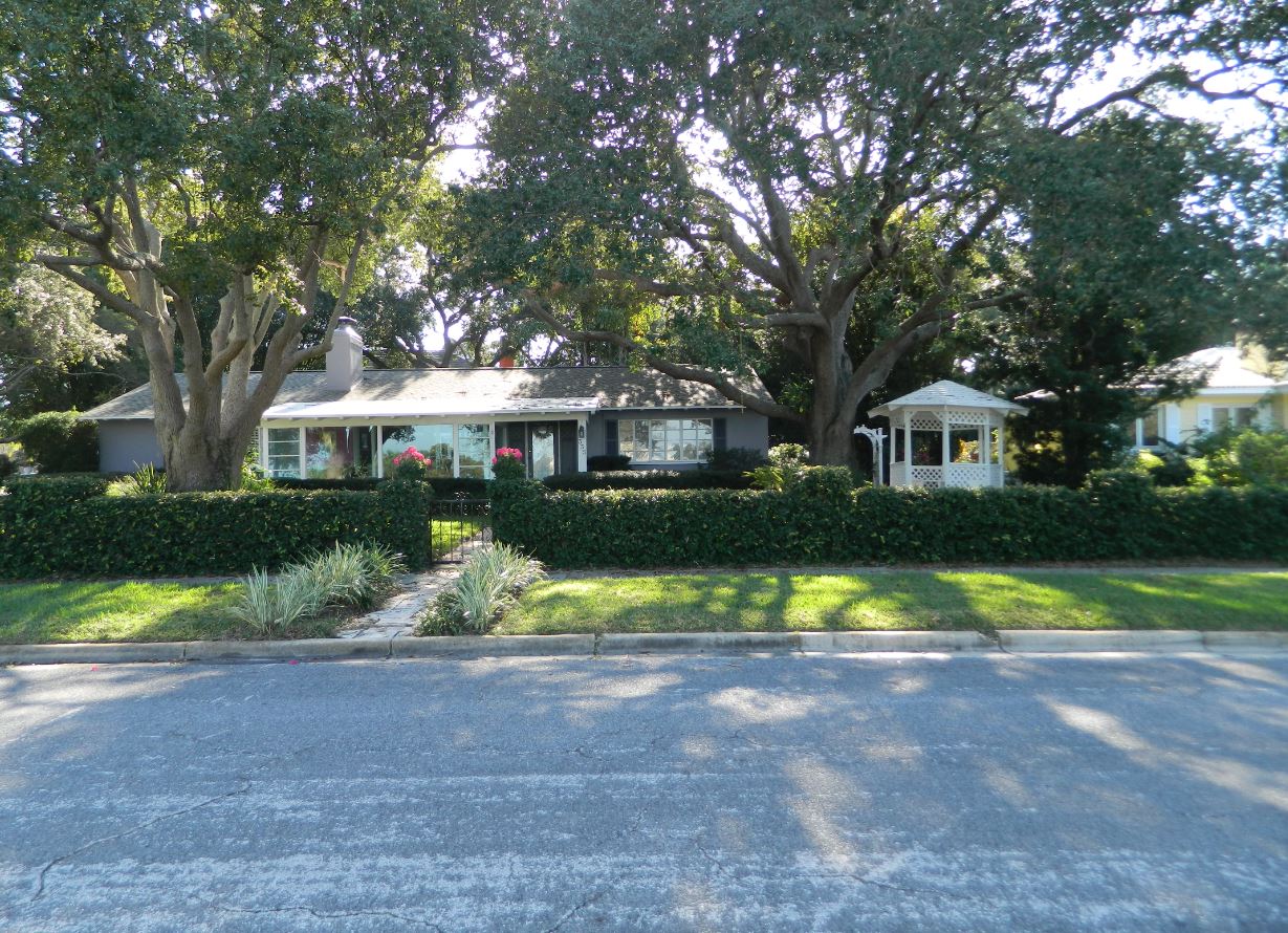 House with large oak trees and gazebo