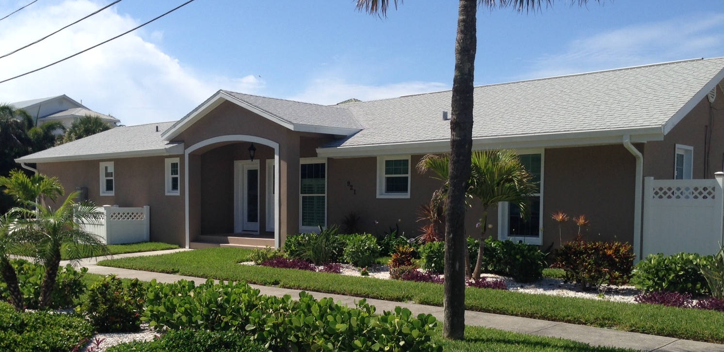 Single-story tan house with palm tree