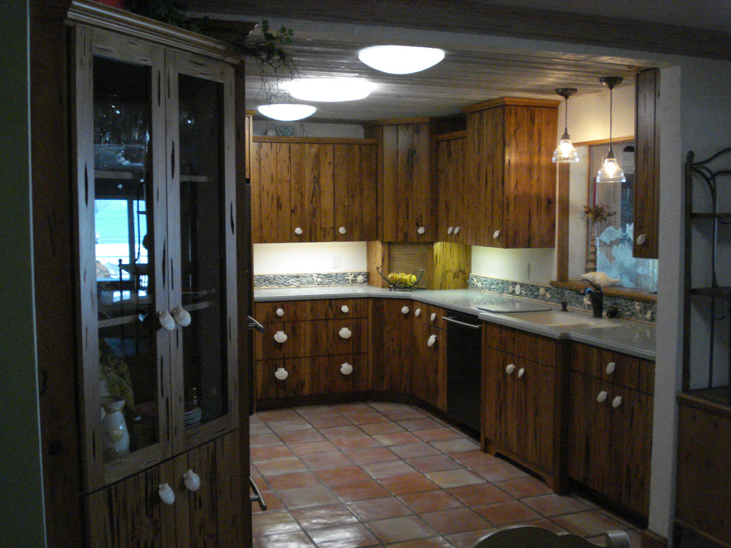Rustic wood-paneled kitchen with tiled floor