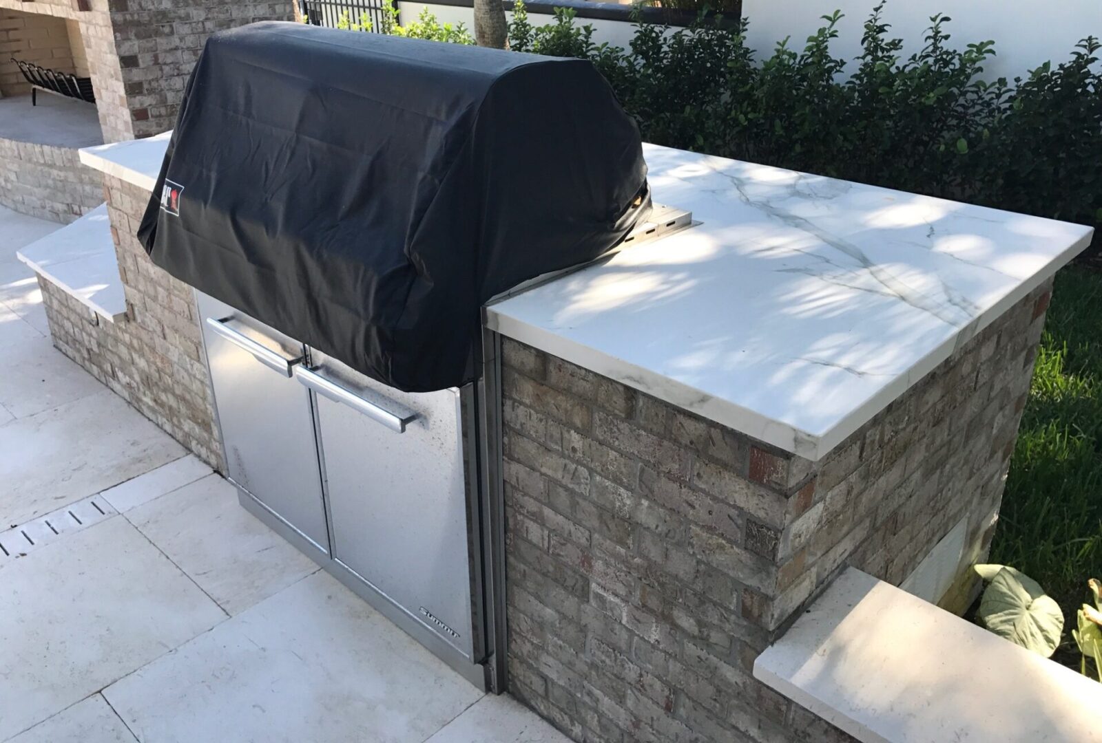 Covered built-in outdoor grill with stone countertop