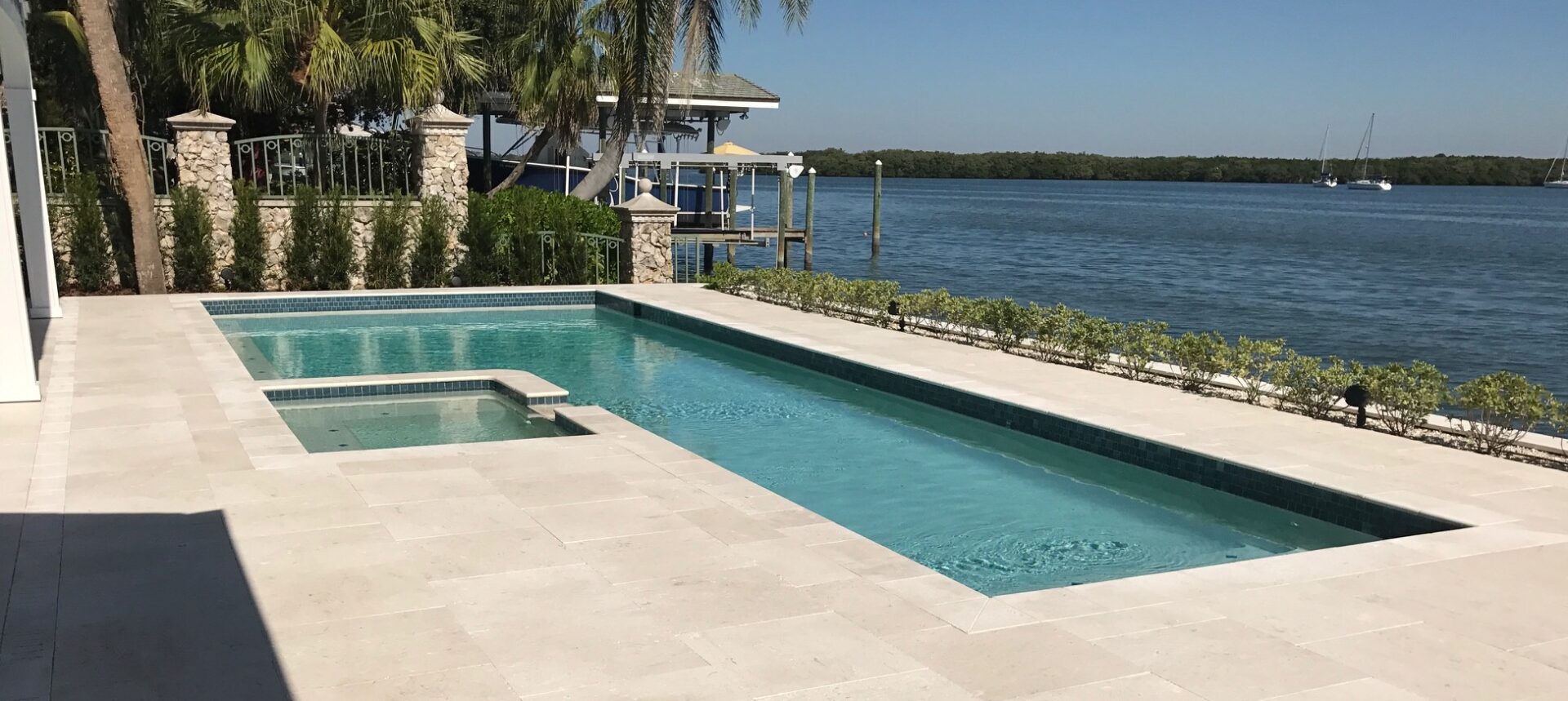 Waterfront rectangular pool and spa with dock