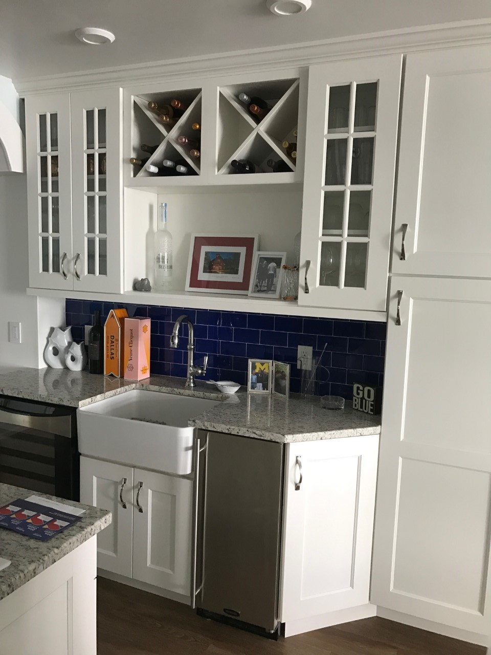 White kitchen wet bar with navy tile backsplash