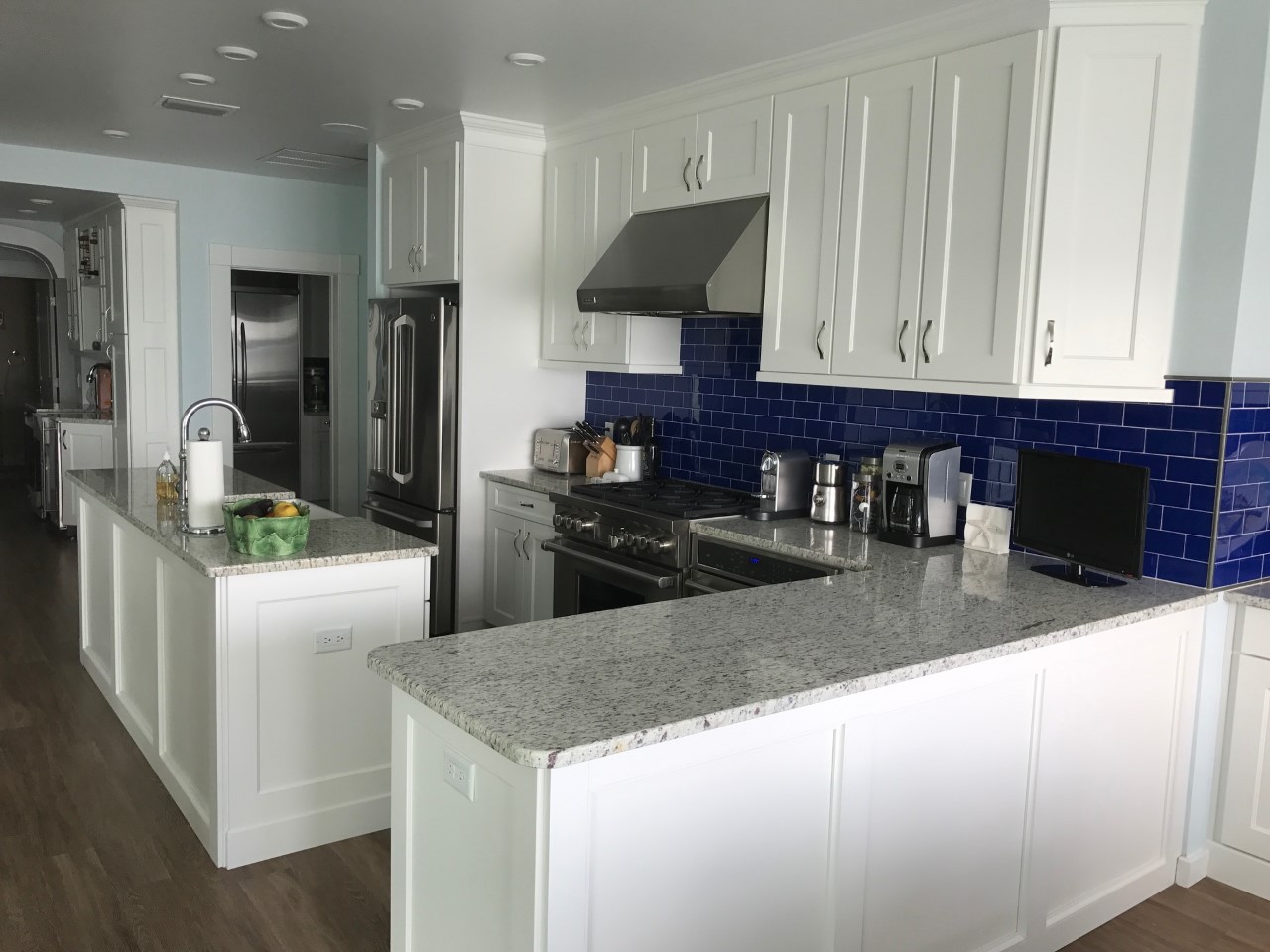 White kitchen island with blue tile backsplash