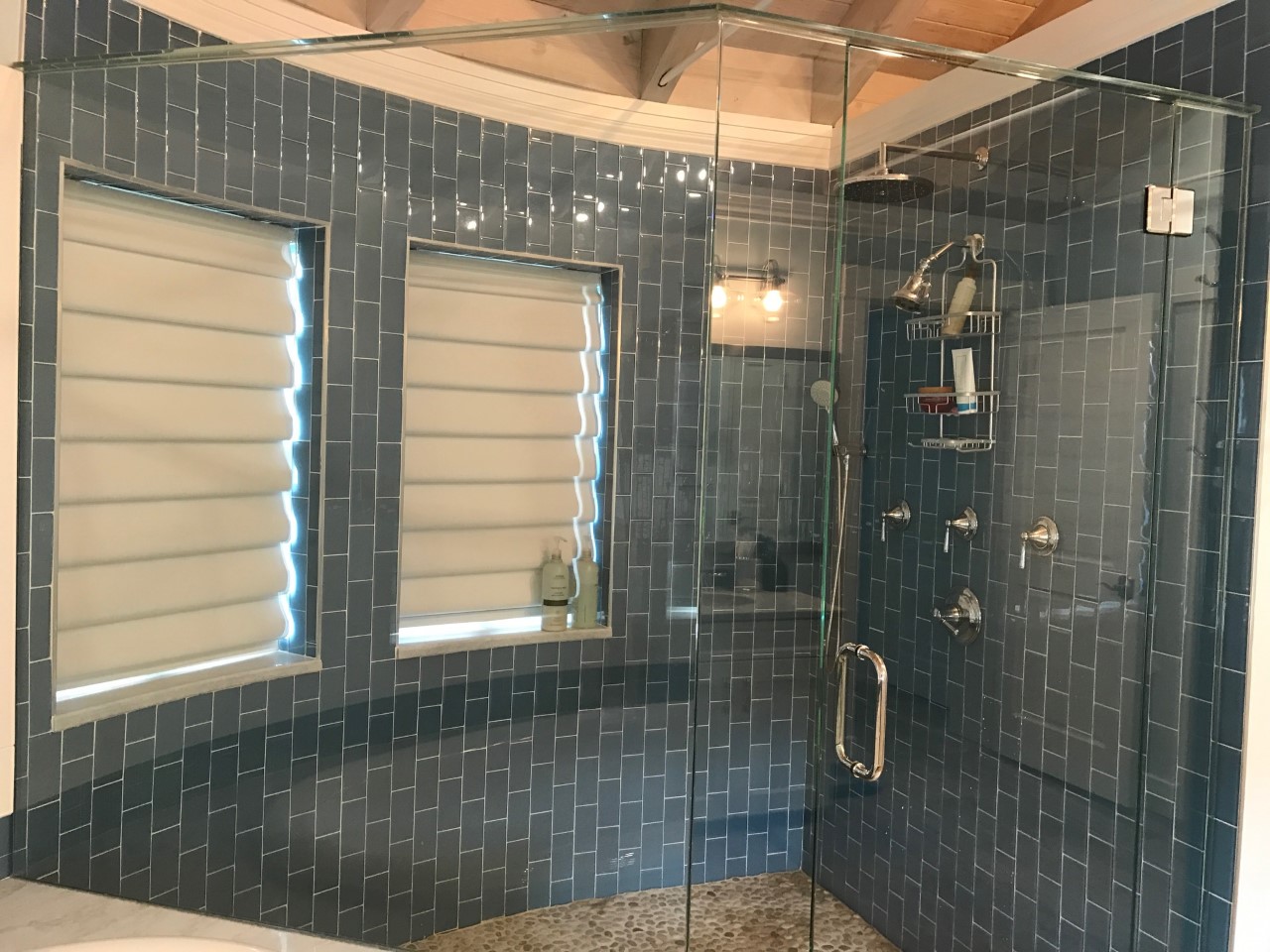 Glass shower with blue subway tile walls