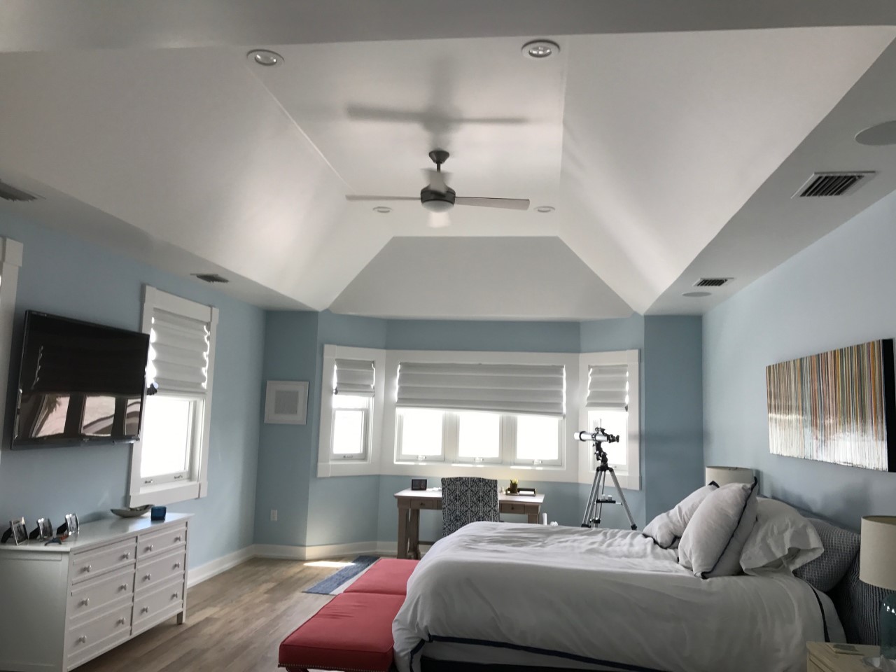 Bright bedroom with bay windows and telescope