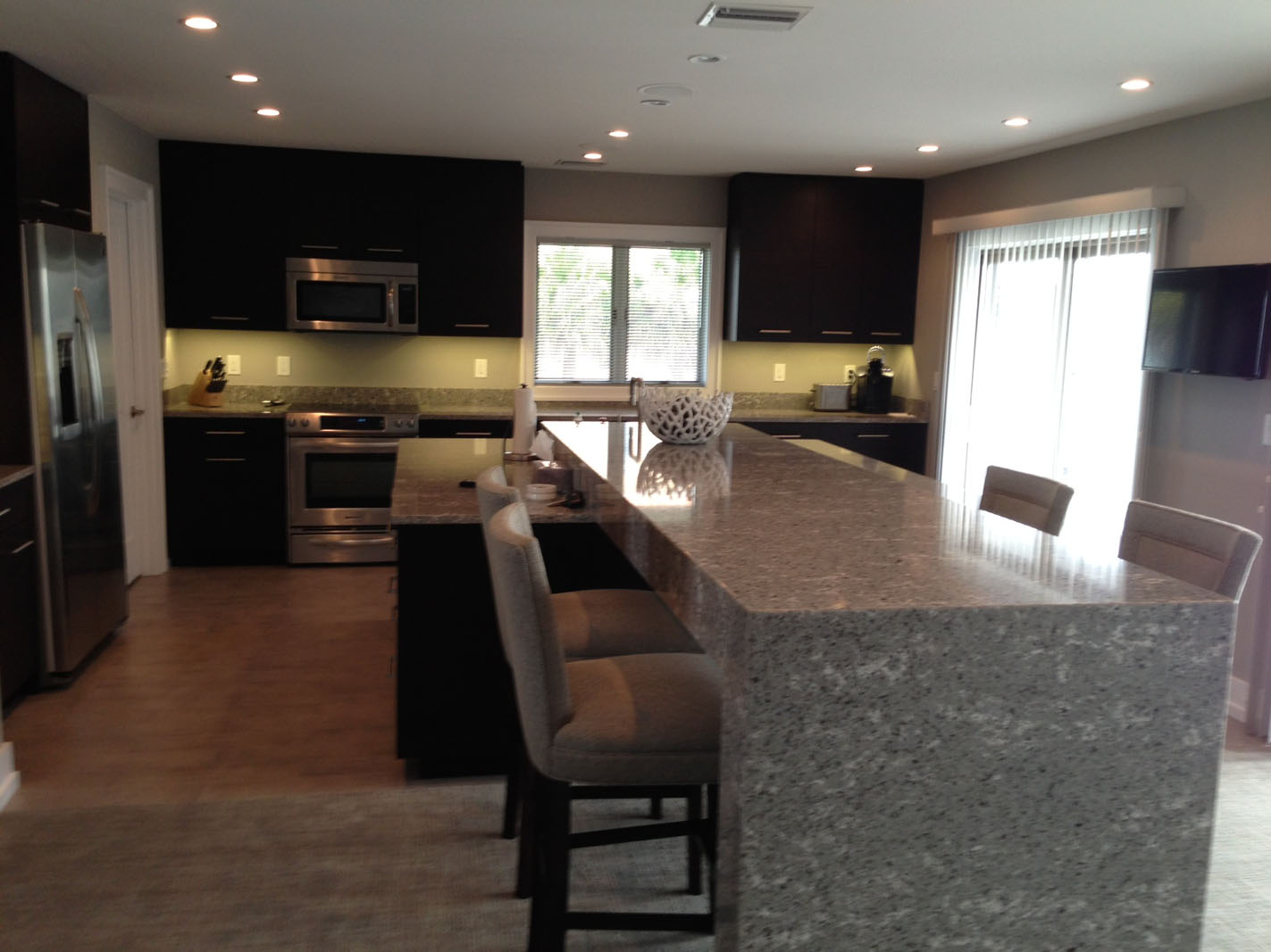 Modern kitchen with large marble island and stools