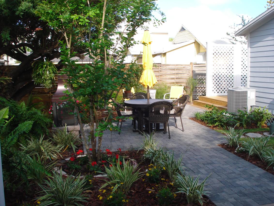 Backyard patio with table, chairs, yellow umbrella