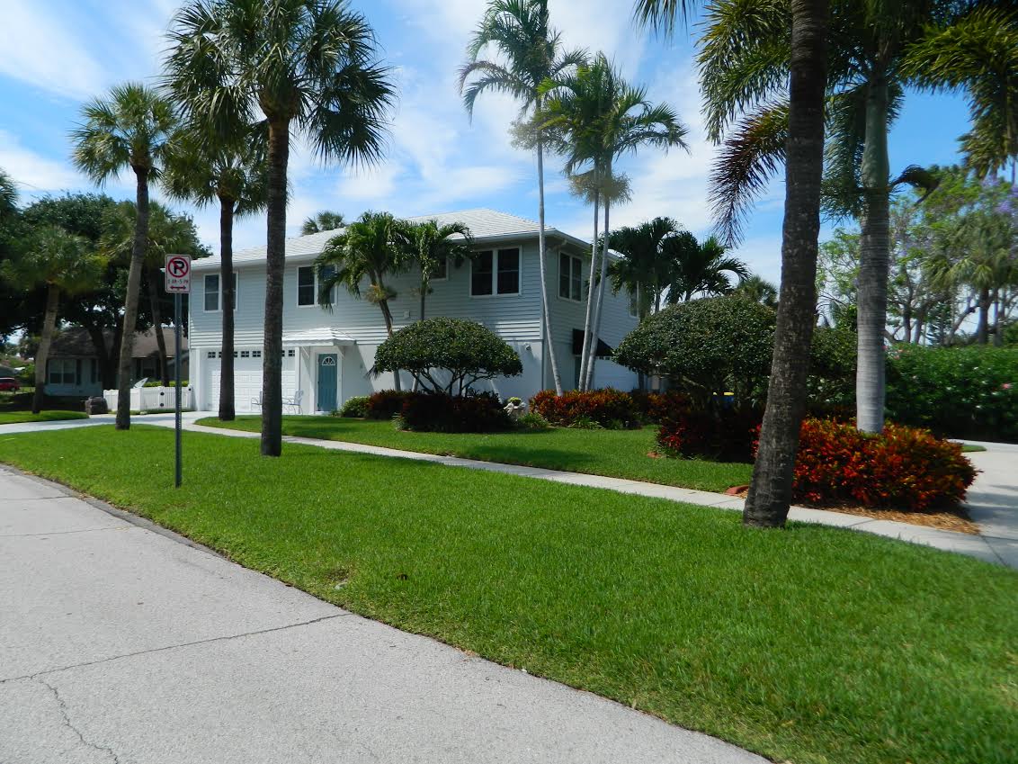 Two-story white house with palm trees