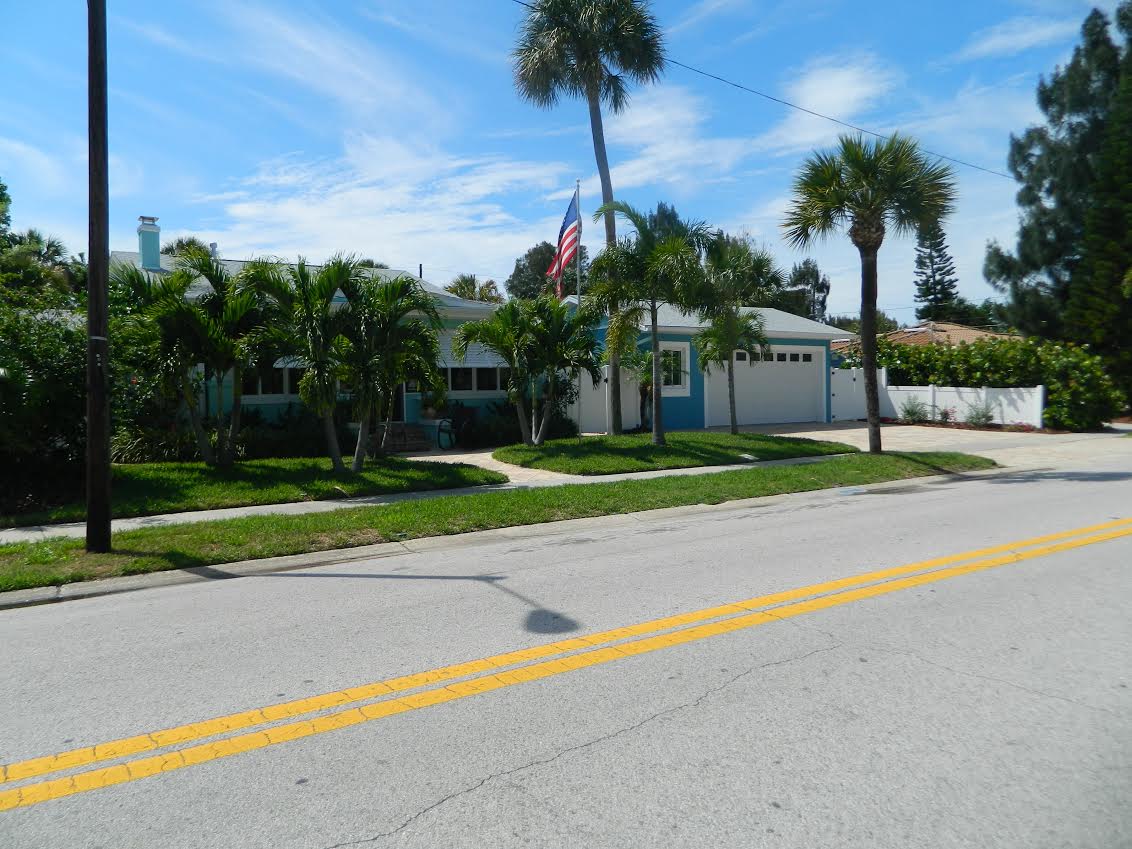 Single-story house with palm trees and American flag