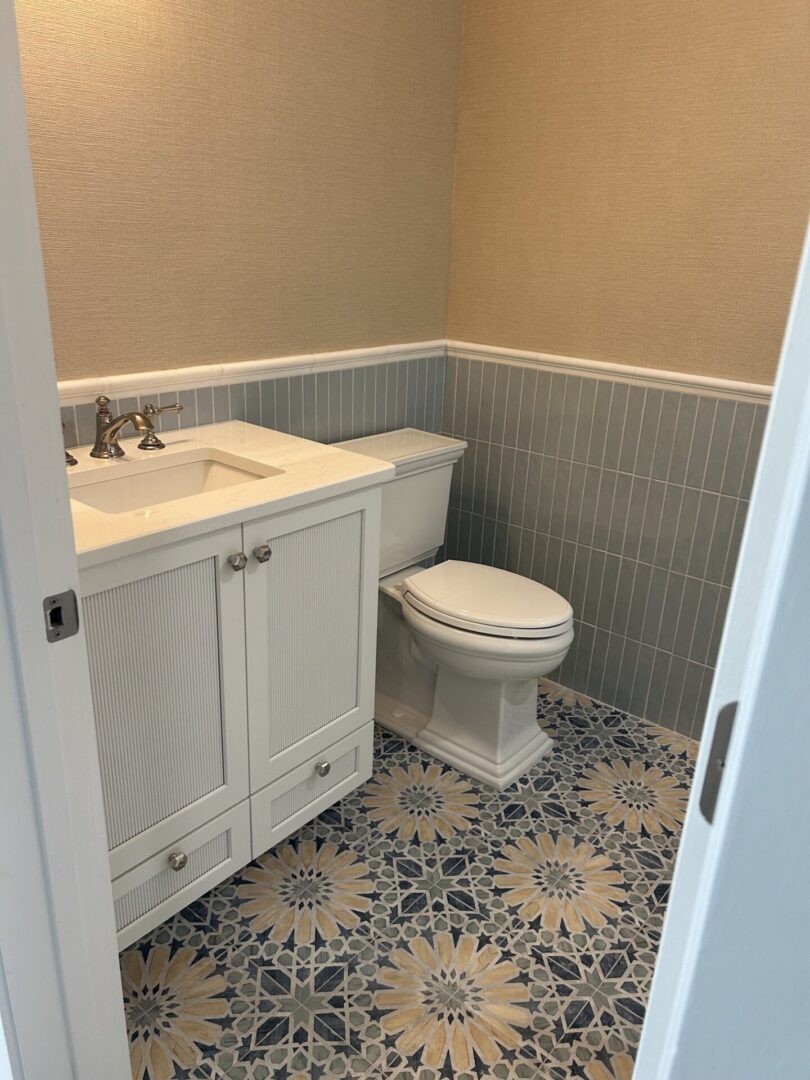 Bathroom with vanity, toilet, patterned tile floor